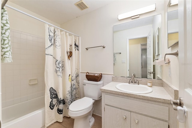 5610 NW 29th Ter, Gainesville, FL 32653 - full bathroom featuring vanity, shower / bath combo with shower curtain, tile patterned floors, and tile walls