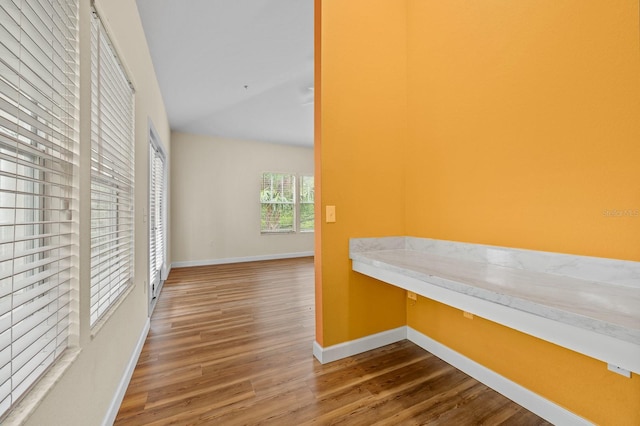 9119 SW 52nd Ave Unit C301, Gainesville, FL 32608 - corridor featuring wood finished floors, a desk, and baseboards