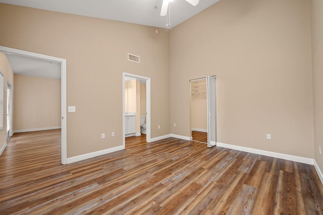 9119 SW 52nd Ave Unit C301, Gainesville, FL 32608 - unfurnished bedroom featuring high vaulted ceiling, wood finished floors, baseboards, a closet, and connected bathroom