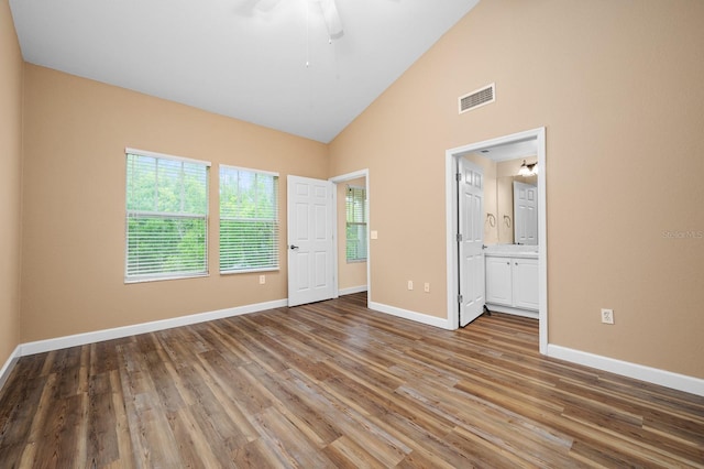 9119 SW 52nd Ave Unit C301, Gainesville, FL 32608 - unfurnished bedroom featuring baseboards, wood finished floors, ensuite bathroom, and high vaulted ceiling