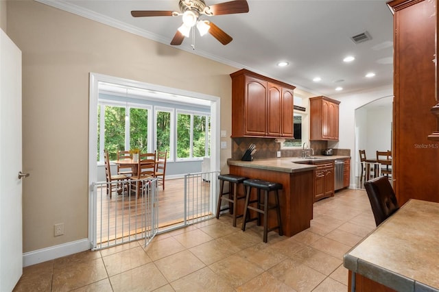 14204 SW 70th St, Archer, FL 32618 - kitchen featuring a sink, crown molding, stainless steel dishwasher, a kitchen bar, and a ceiling fan