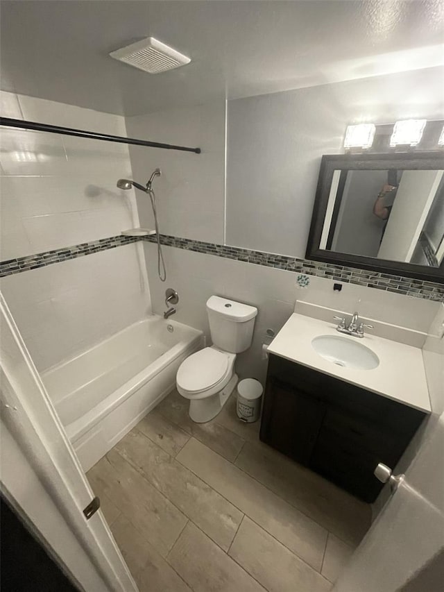 6019 W Fern St, Tampa, FL 33634 - bathroom featuring toilet, shower / washtub combination, vanity, and tile walls