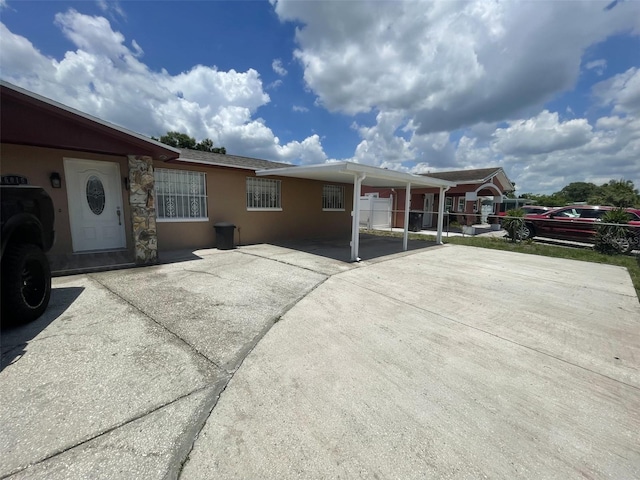 6019 W Fern St, Tampa, FL 33634 - view of front of property featuring driveway, an attached carport, and stucco siding
