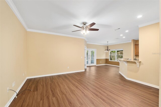 3664 NW 55th Ln, Gainesville, FL 32653 - unfurnished living room with ceiling fan, baseboards, wood finished floors, a chandelier, and crown molding