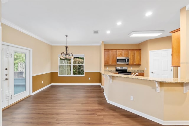 3664 NW 55th Ln, Gainesville, FL 32653 - kitchen featuring stainless steel appliances, wood finished floors, a chandelier, a breakfast bar, and recessed lighting