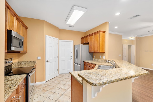 3664 NW 55th Ln, Gainesville, FL 32653 - kitchen with stainless steel appliances, a sink, a peninsula, a kitchen breakfast bar, and recessed lighting