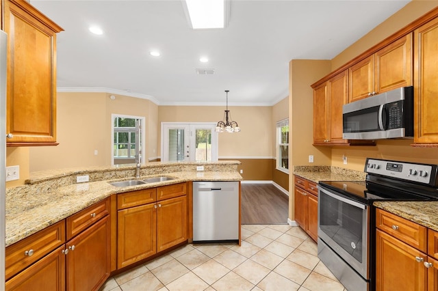 3664 NW 55th Ln, Gainesville, FL 32653 - kitchen featuring stainless steel appliances, a sink, a peninsula, brown cabinetry, and ornamental molding