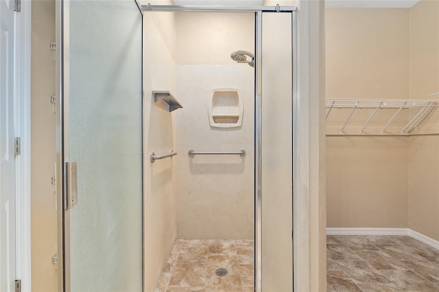 3664 NW 55th Ln, Gainesville, FL 32653 - full bath featuring a shower stall, a spacious closet, and baseboards