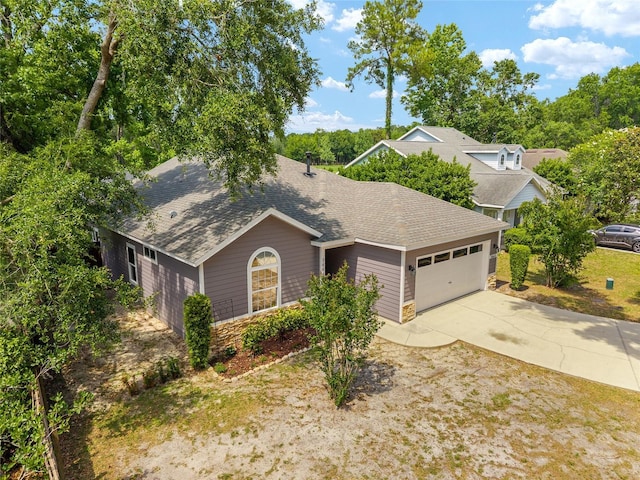 3664 NW 55th Ln, Gainesville, FL 32653 - view of front facade featuring roof with shingles, a garage, stone siding, and concrete driveway