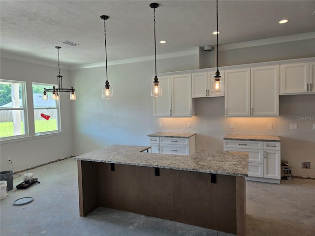 kitchen with white cabinetry, crown molding, a chandelier, light stone counters, and concrete flooring