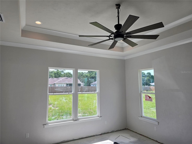unfurnished room with a raised ceiling, healthy amount of natural light, ceiling fan, recessed lighting, and ornamental molding