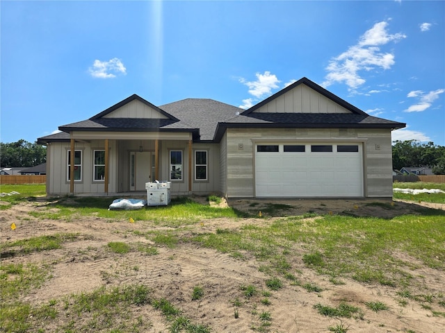 view of front of house with a garage, board and batten siding, driveway, and roof with shingles