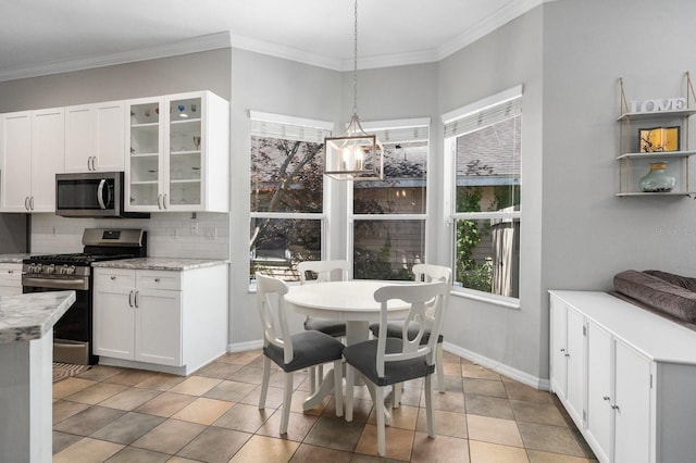 kitchen featuring stainless steel appliances, backsplash, white cabinets, glass insert cabinets, and crown molding