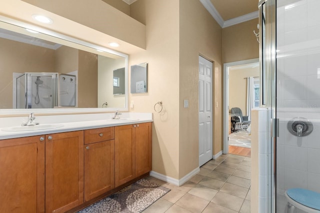 full bathroom with ornamental molding, a shower stall, double vanity, tile patterned floors, and baseboards