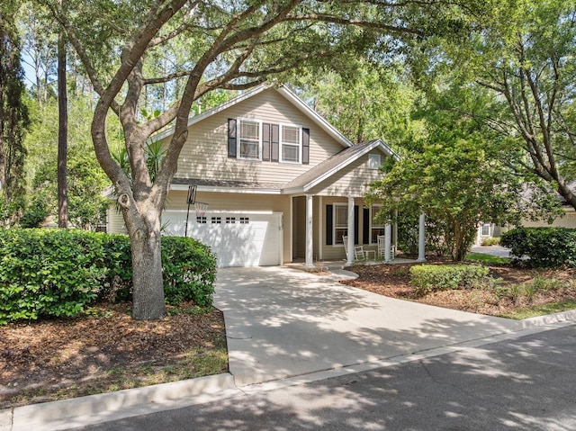 traditional-style home with a porch, an attached garage, and concrete driveway