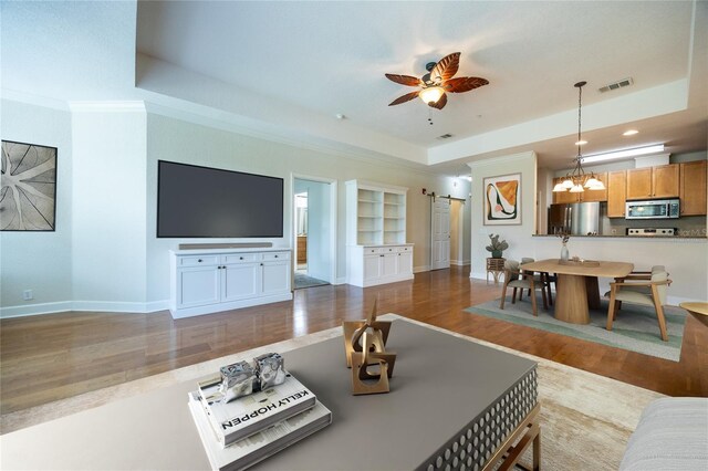 4715 SW 91st Dr Unit 302, Gainesville, FL 32608 - living area with wood finished floors, a barn door, a raised ceiling, a ceiling fan, and recessed lighting