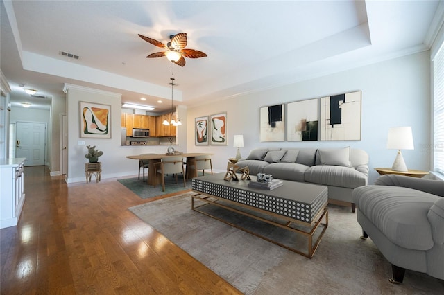 4715 SW 91st Dr Unit 302, Gainesville, FL 32608 - living area featuring a tray ceiling, ceiling fan, wood finished floors, baseboards, and ornamental molding
