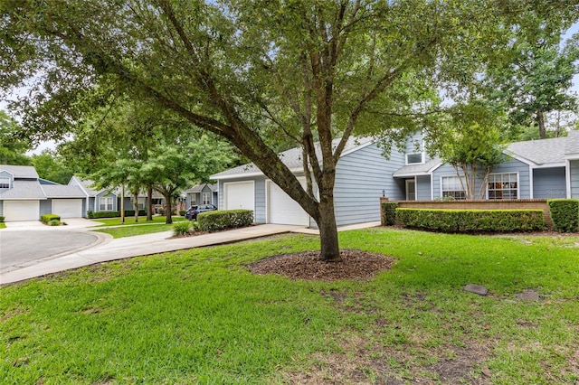 obstructed view of property with a front lawn, concrete driveway, and a residential view