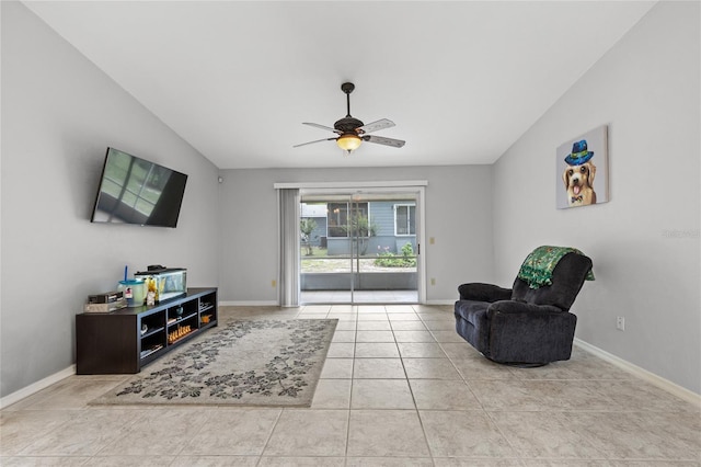 sitting room with ceiling fan, baseboards, tile patterned flooring, and vaulted ceiling