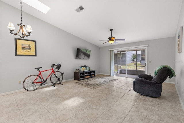 living room with vaulted ceiling, tile patterned flooring, a skylight, baseboards, and a chandelier