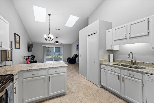 kitchen with a skylight, a sink, vaulted ceiling, white dishwasher, and a chandelier
