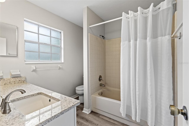 bathroom with wood finished floors, vanity, toilet, and shower / bath combination with curtain