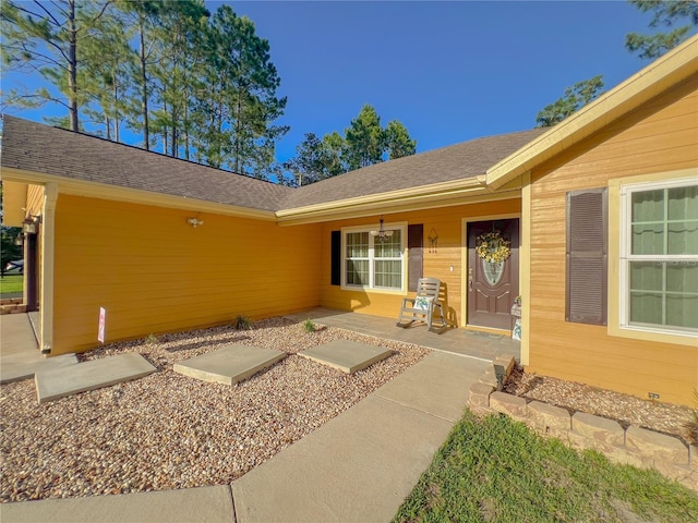 609 NE 2nd St, Williston, FL 32696 - doorway to property featuring a porch and roof with shingles
