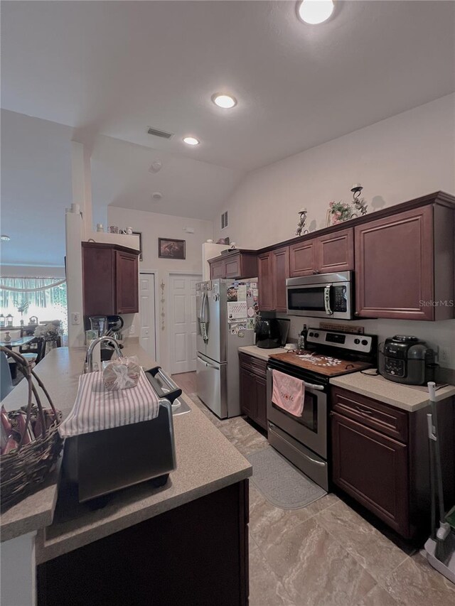 609 NE 2nd St, Williston, FL 32696 - kitchen featuring stainless steel appliances, light countertops, dark brown cabinets, a peninsula, and recessed lighting