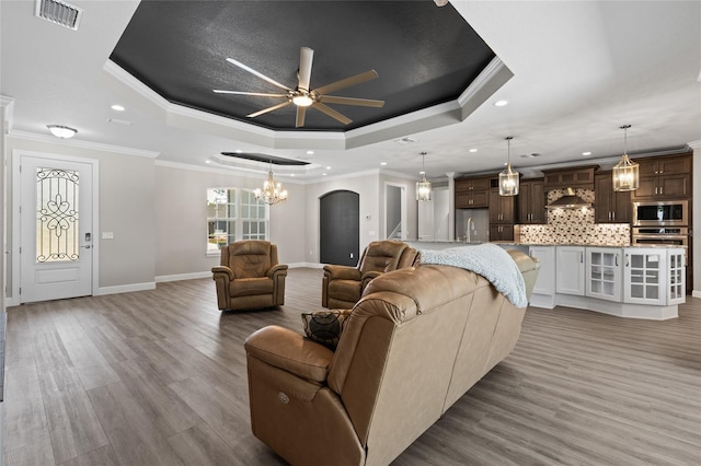 17781 SW 72nd Street Rd, Dunnellon, FL 34432 - living area featuring a raised ceiling, a ceiling fan, a chandelier, wood finished floors, and recessed lighting