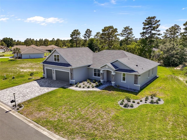 17781 SW 72nd Street Rd, Dunnellon, FL 34432 - ranch-style home with decorative driveway, a front yard, stucco siding, and view of scattered trees