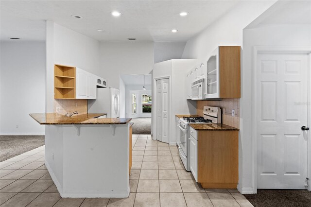 kitchen with white appliances, light colored carpet, a peninsula, a kitchen breakfast bar, and open shelves