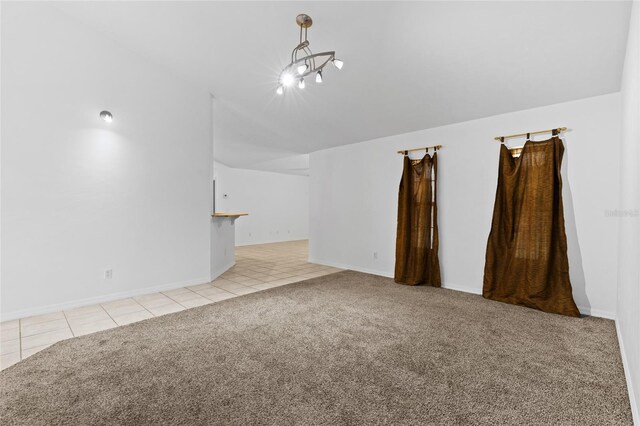 unfurnished living room featuring vaulted ceiling, light carpet, light tile patterned floors, a chandelier, and baseboards