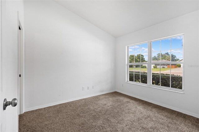 unfurnished room with vaulted ceiling, carpet flooring, and baseboards