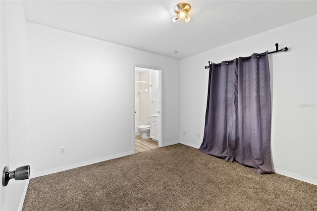 empty room featuring light colored carpet and baseboards