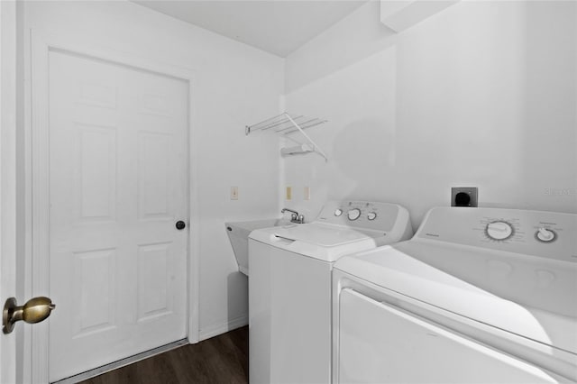 clothes washing area featuring washer and clothes dryer, dark wood finished floors, and baseboards