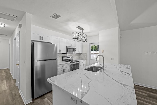 415 NW 10th St, Gainesville, FL 32601 - kitchen featuring stainless steel appliances, a sink, dark wood-style flooring, and white cabinets