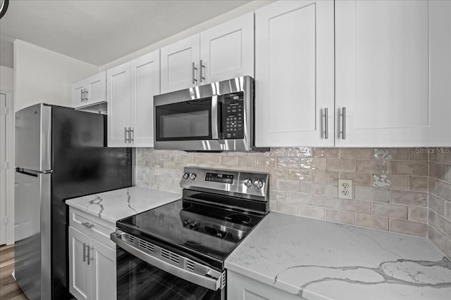 415 NW 10th St, Gainesville, FL 32601 - kitchen featuring stainless steel appliances, white cabinetry, light stone countertops, and tasteful backsplash