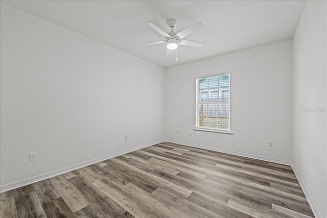 415 NW 10th St, Gainesville, FL 32601 - empty room with wood finished floors, a ceiling fan, and baseboards