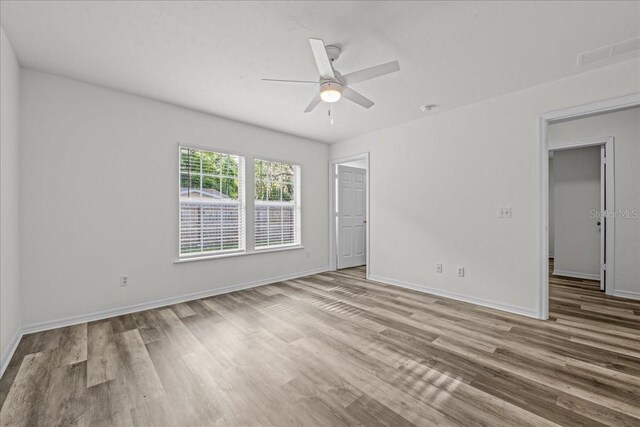 415 NW 10th St, Gainesville, FL 32601 - unfurnished bedroom with wood finished floors, baseboards, and ceiling fan