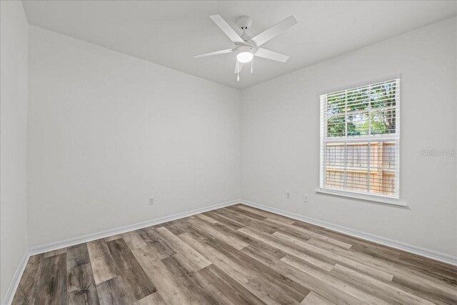 415 NW 10th St, Gainesville, FL 32601 - empty room featuring wood finished floors, baseboards, and a ceiling fan