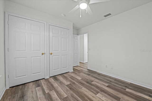 415 NW 10th St, Gainesville, FL 32601 - unfurnished bedroom featuring baseboards, wood finished floors, and a ceiling fan