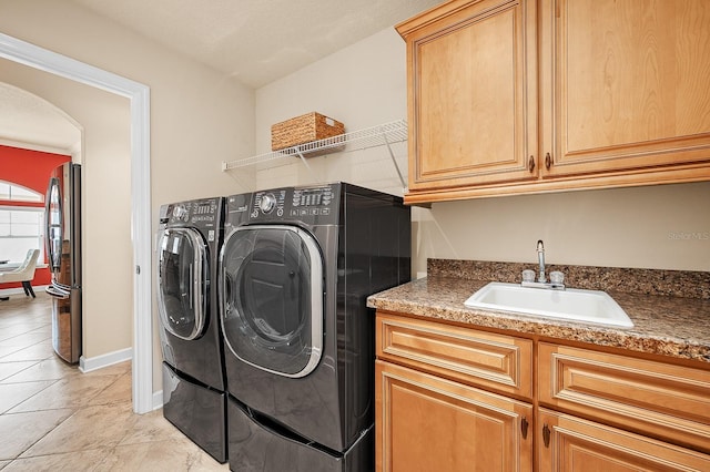 19152 NW 228th Way, High Springs, FL 32643 - laundry area featuring washing machine and dryer, cabinet space, arched walkways, and light tile patterned flooring