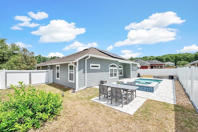 19152 NW 228th Way, High Springs, FL 32643 - rear view of house with solar panels, a patio, an in-ground hot tub, and roof with shingles