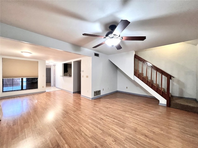 5830 SW 9th Pl, Gainesville, FL 32607 - unfurnished living room featuring light wood-style flooring, ceiling fan, baseboards, and stairway