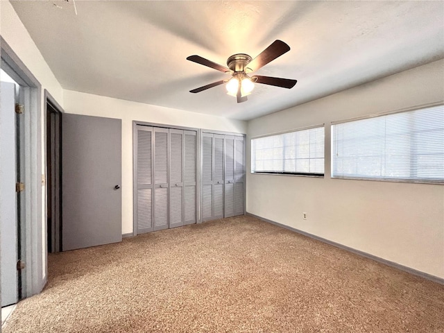 5830 SW 9th Pl, Gainesville, FL 32607 - unfurnished bedroom featuring multiple closets, carpet floors, baseboards, and a ceiling fan
