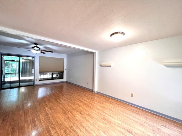 5830 SW 9th Pl, Gainesville, FL 32607 - empty room with wood finished floors, baseboards, ceiling fan, and a textured ceiling