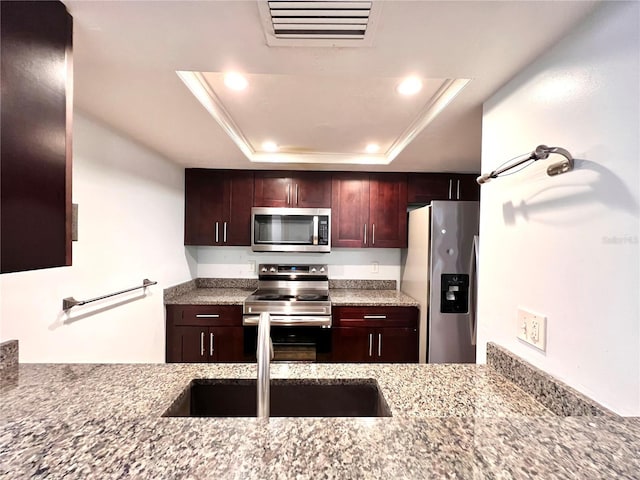 5830 SW 9th Pl, Gainesville, FL 32607 - kitchen with appliances with stainless steel finishes, a raised ceiling, recessed lighting, light stone countertops, and a sink