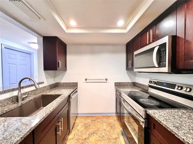 5830 SW 9th Pl, Gainesville, FL 32607 - kitchen featuring appliances with stainless steel finishes, a sink, a raised ceiling, baseboards, and stone counters