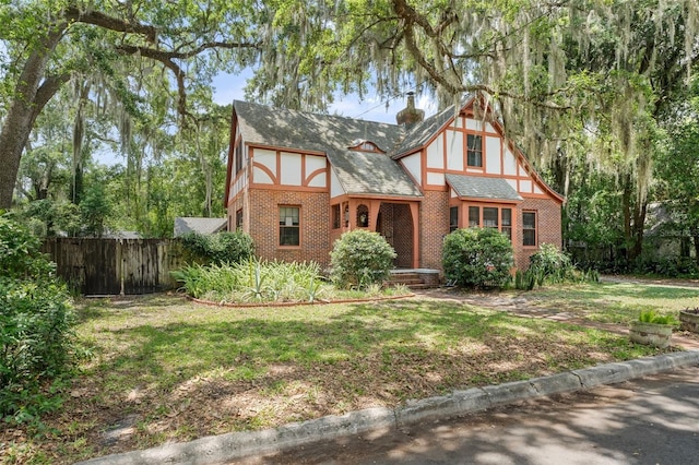 535 NE 9th Ave, Gainesville, FL 32601 - tudor house featuring brick siding, a shingled roof, and a chimney