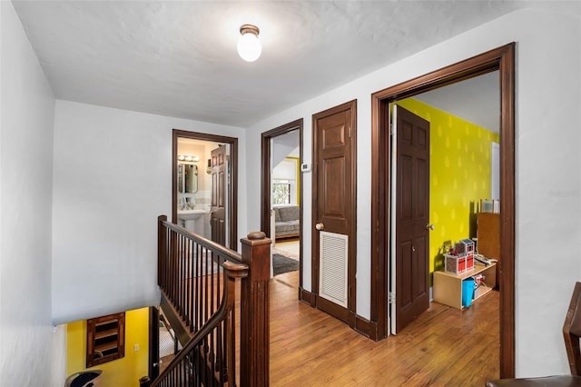 535 NE 9th Ave, Gainesville, FL 32601 - corridor with an upstairs landing, light wood finished floors, and baseboards